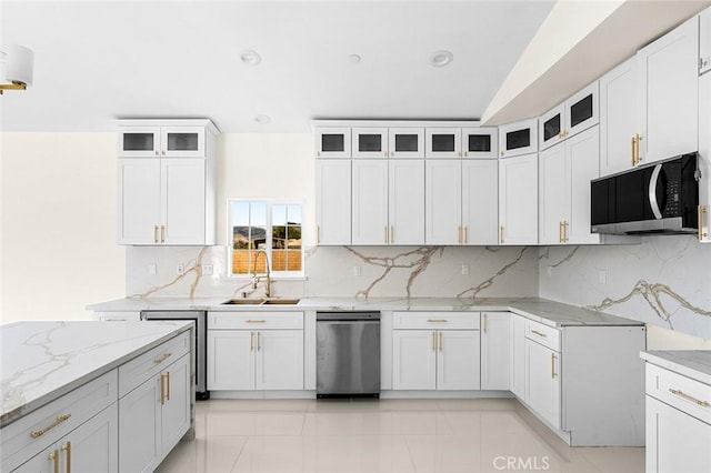 kitchen featuring glass insert cabinets, white cabinets, and light stone countertops