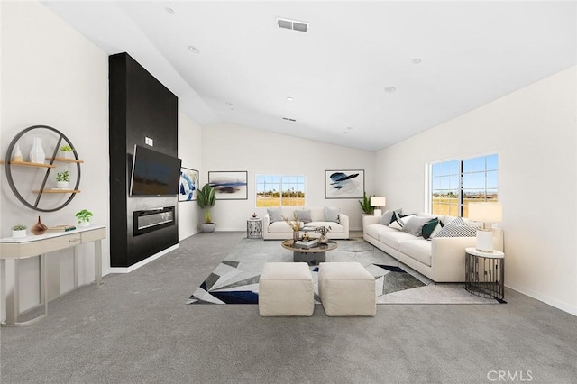 living room with a healthy amount of sunlight, visible vents, a glass covered fireplace, and light colored carpet