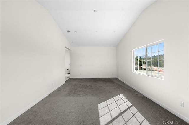 unfurnished room featuring high vaulted ceiling, baseboards, and dark carpet