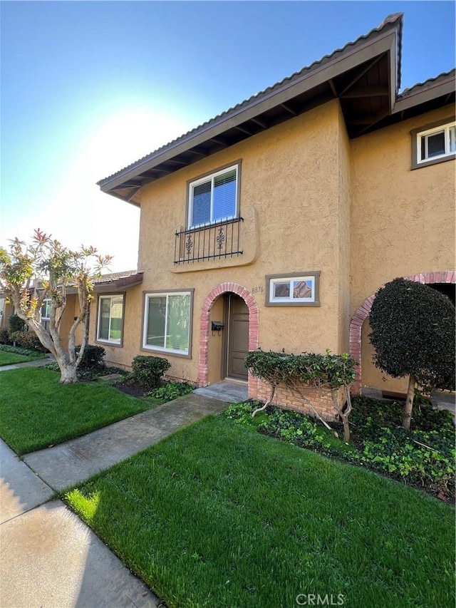 view of front of house with a front yard and stucco siding