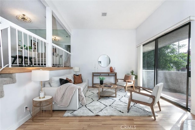 living room with stairs, wood finished floors, and visible vents