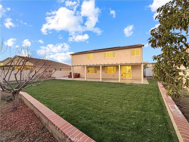 rear view of property featuring a lawn, a patio area, a fenced backyard, and stucco siding