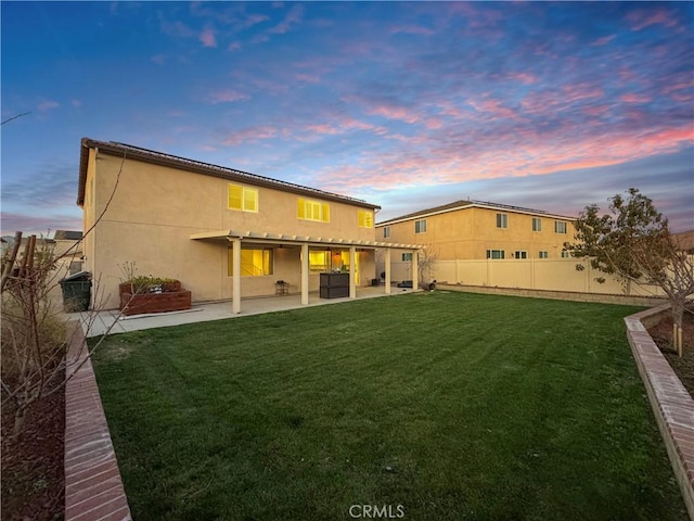 rear view of house with a patio area, a fenced backyard, a yard, and stucco siding