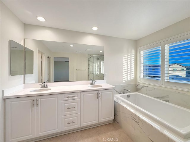 full bathroom with double vanity, a sink, a bath, and a shower stall