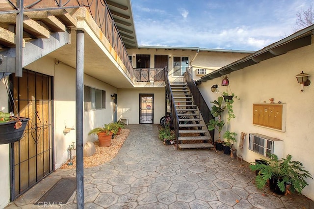 view of exterior entry featuring a gate and stucco siding