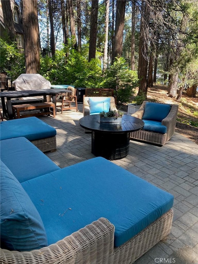 view of patio with an outdoor living space with a fire pit