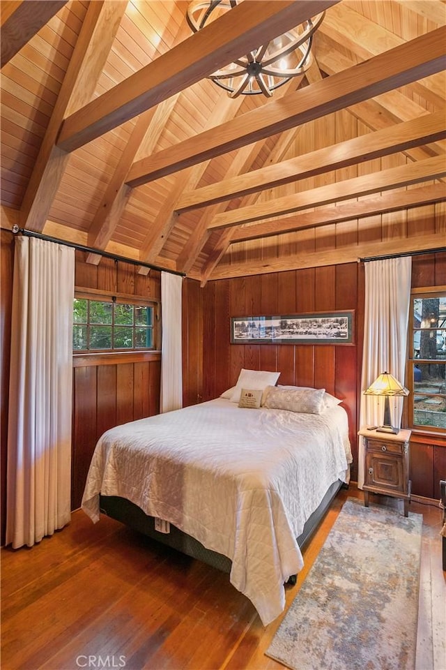 bedroom with wooden ceiling, wooden walls, lofted ceiling with beams, and wood finished floors