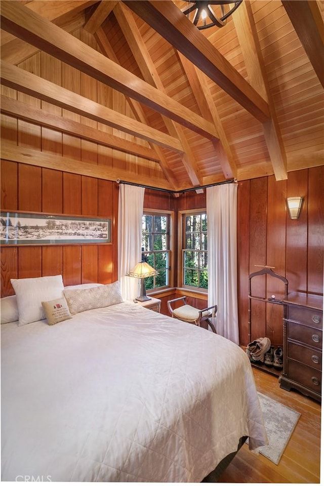 bedroom featuring light wood-style floors, wooden ceiling, wooden walls, and lofted ceiling with beams