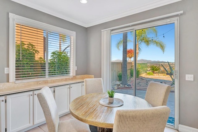 dining room with light tile patterned floors and crown molding