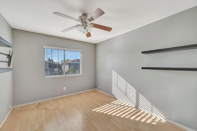 unfurnished room featuring light wood finished floors, baseboards, and a ceiling fan