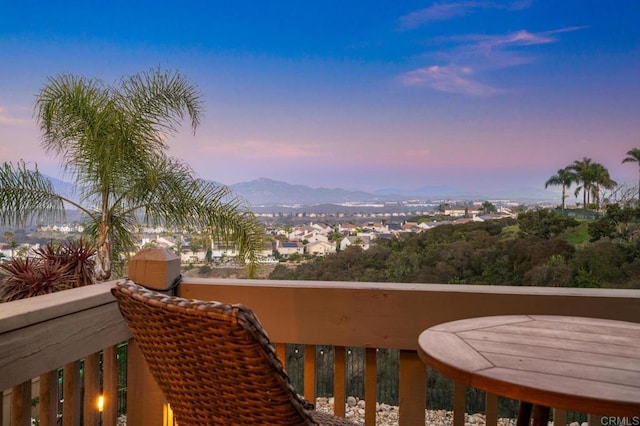 balcony at dusk featuring a mountain view