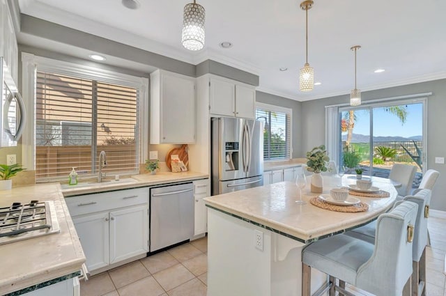 kitchen with stainless steel appliances, a center island, white cabinets, and light countertops