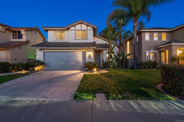 traditional-style house with a garage, concrete driveway, a front yard, and stucco siding