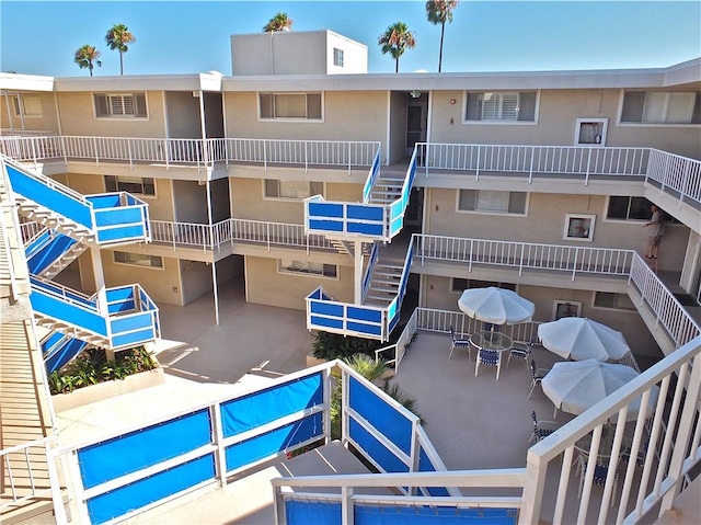 view of building exterior with stairway and a pool