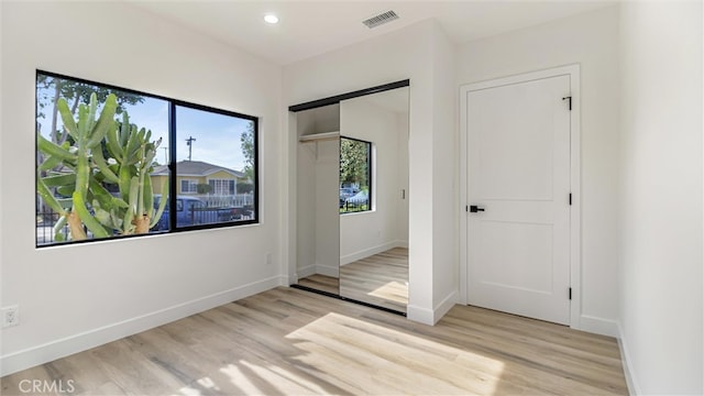 unfurnished bedroom featuring recessed lighting, visible vents, baseboards, a closet, and light wood finished floors