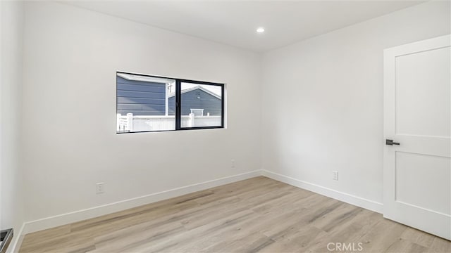 unfurnished room featuring light wood-style flooring, baseboards, and recessed lighting