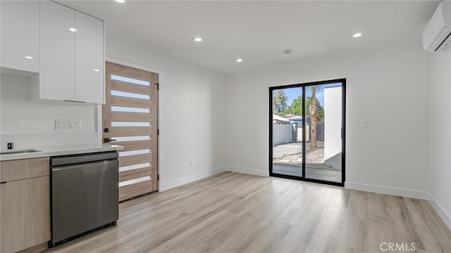 kitchen with dishwasher, light wood-style flooring, modern cabinets, white cabinetry, and a wall mounted AC