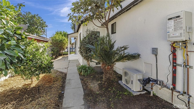 view of side of property featuring water heater, ac unit, and stucco siding