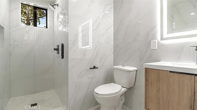 bathroom with toilet, a shower stall, tile walls, and vanity