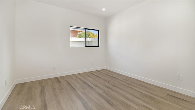 spare room with light wood finished floors, baseboards, and recessed lighting