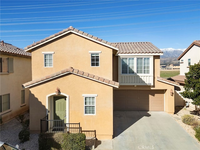 view of front of home featuring stucco siding, concrete driveway, a garage, a tiled roof, and a mountain view