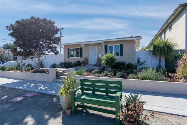 ranch-style home with fence and stucco siding