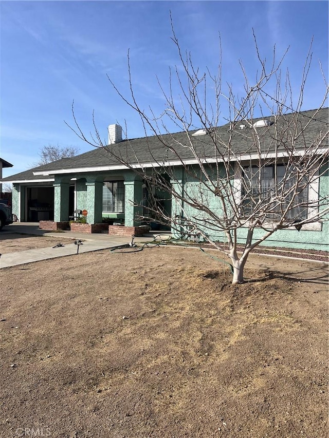 view of front of house featuring a chimney and a front yard