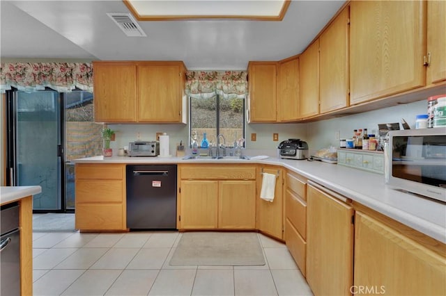 kitchen featuring light countertops, a sink, visible vents, and black appliances