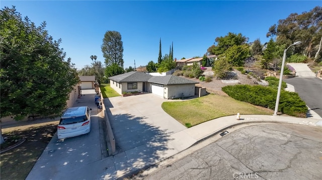 view of front of property featuring driveway, a garage, and a front yard