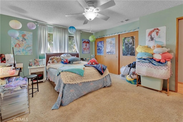 bedroom with ceiling fan, visible vents, a textured ceiling, and carpet flooring