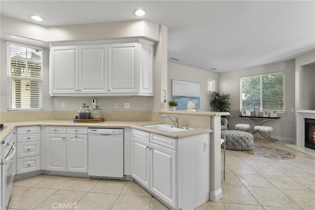 kitchen with light countertops, white appliances, and white cabinets