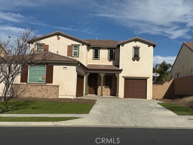 view of front facade with a garage, driveway, fence, and stucco siding