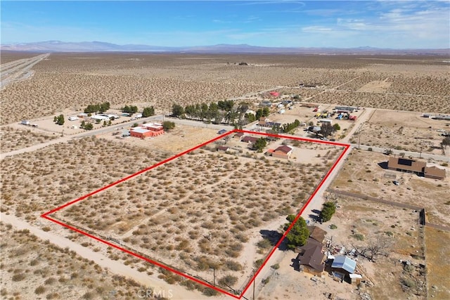 birds eye view of property with a mountain view and view of desert