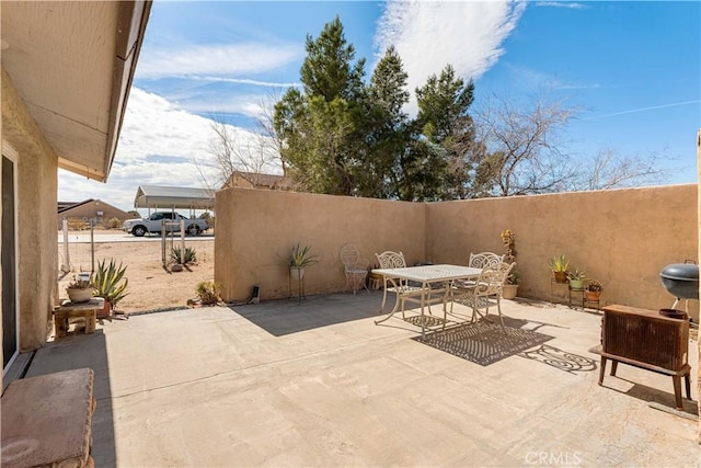 view of patio with outdoor dining space and fence