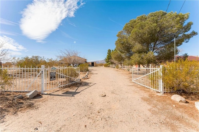 exterior space with a gate, a rural view, and fence