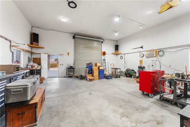 garage featuring a wall mounted AC and a workshop area