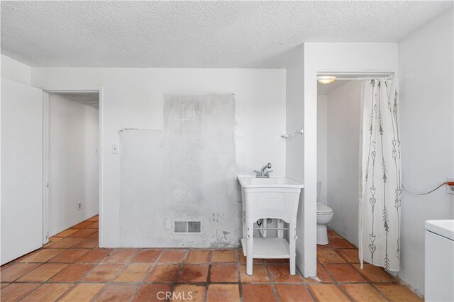 bathroom with visible vents, a textured ceiling, and toilet