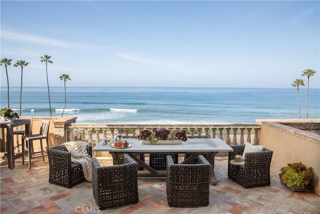 view of patio with a view of the beach, outdoor dining area, and a water view