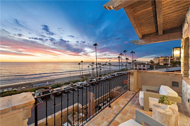 balcony with a water view and a beach view