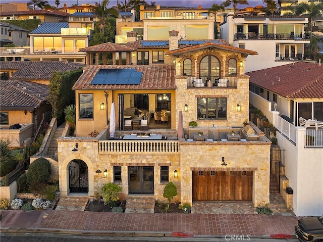 view of front of home featuring a garage, stone siding, and decorative driveway