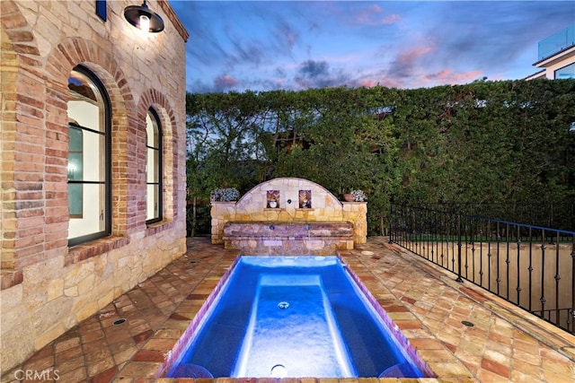 view of swimming pool featuring an in ground hot tub, fence, and a patio