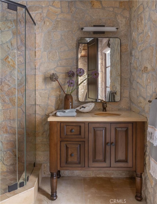 bathroom with a shower stall, vanity, and tile patterned floors