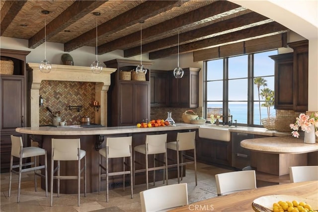 kitchen featuring a water view, pendant lighting, light countertops, and a kitchen breakfast bar