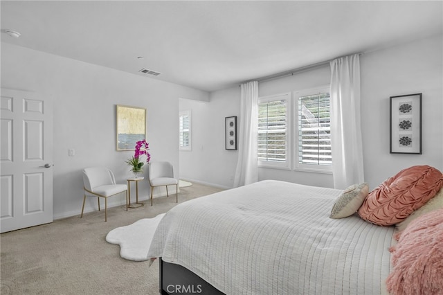 bedroom featuring baseboards, visible vents, and light colored carpet