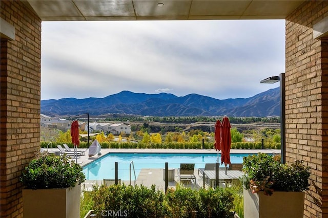 pool with a patio area and a mountain view