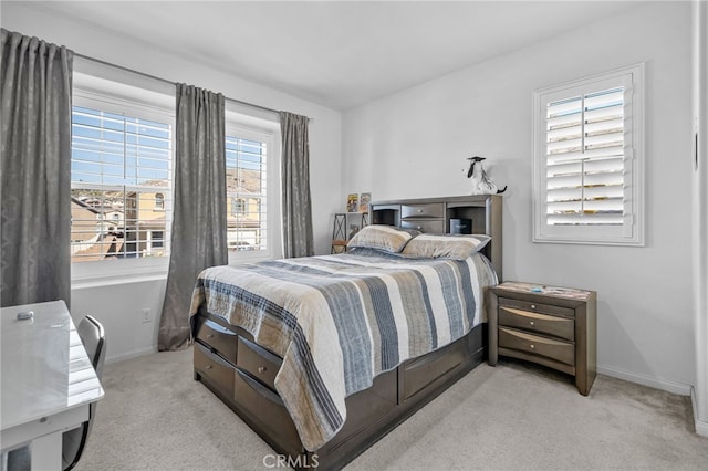 bedroom featuring light colored carpet and baseboards