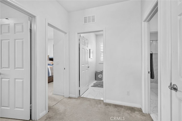 corridor with baseboards, marble finish floor, visible vents, and light colored carpet