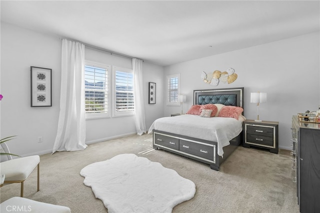 bedroom featuring light colored carpet and baseboards