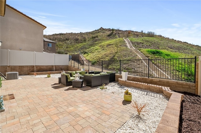 view of patio / terrace featuring a fenced backyard, an outdoor living space, and central AC unit