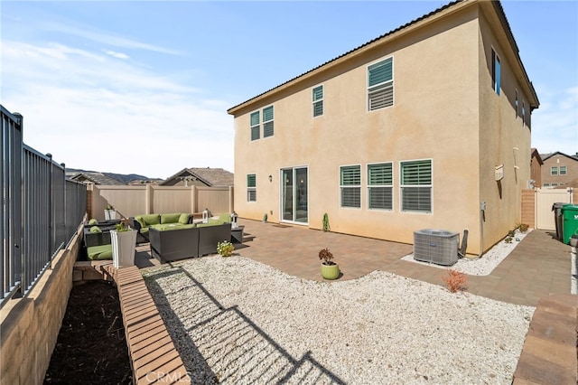 rear view of property featuring a fenced backyard, a patio area, an outdoor living space, and stucco siding